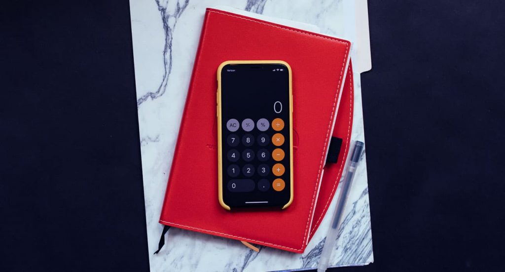 Uma calculadora sobre uma agenda vermelha.